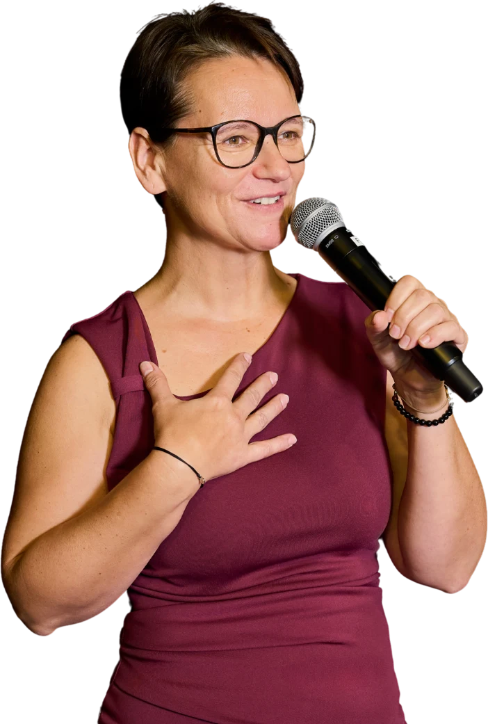 Silvia Schlagbauer mit Mikrofon, eine Hand am Herzen